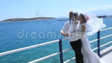 结婚纪念日。 新婚快乐，戴着新娘的面纱在海上海岸。