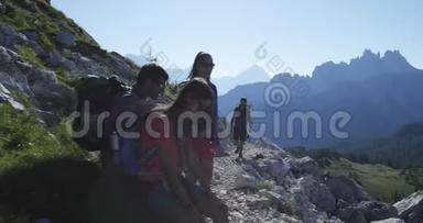 四个朋友沿着徒步小径散步，放松一下。 一群朋友在山上进行夏季探险之旅