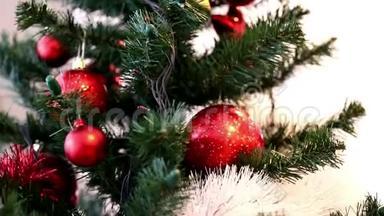 圣诞树上<strong>装饰</strong>着红色的花苞，白色和红色的花环，金色的星星和叮当的<strong>铃铛</strong>