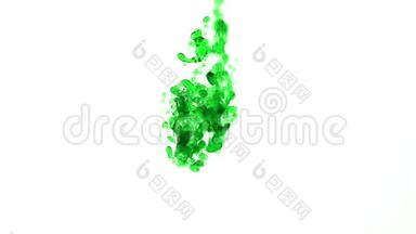 绿色的油滴在水中倾泻下来，然后上升到顶部缓慢的运动
