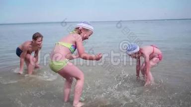两个女孩和一个男人在海滩上泼水。 在炎热的夏日里，双胞胎泼水，欢笑和良好的心情
