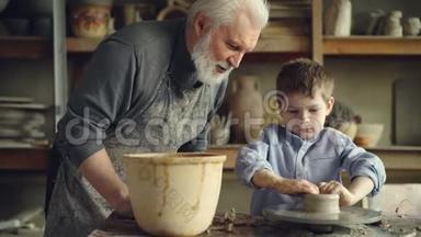 <strong>专心</strong>致志的小男孩在纺车上把粘土塑成陶瓷锅，他有经验的祖父是