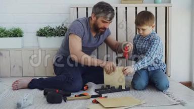 大胡子的父亲和小可爱的儿子在家里用木<strong>床</strong>单做鸟舍。 <strong>儿童</strong>和父母观念