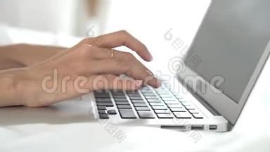 年轻的亚洲女人在卧室里用<strong>笔记本</strong>电脑休闲，女孩在网上用<strong>键盘</strong>打<strong>笔记本</strong>