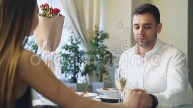 穿得漂亮的帅哥在餐馆吃饭时向年轻女士<strong>求婚</strong>。 他在说话然后给她