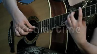 专注于手指指指点点的弦。 一个弹声吉他的女孩的手的特写。