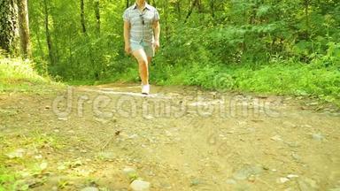 一位年轻的女<strong>游客</strong>正沿着一条<strong>森林</strong>小径散步。