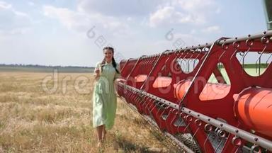 穿着衣服的村民女孩在后台的农田里，在农机旁走着金色的田野