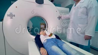 医生控制男孩的CT扫描。