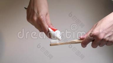 把<strong>牙膏</strong>从试管里挤到木制牙刷上。 带有新鲜白色<strong>牙膏</strong>的牙刷白色刚毛。