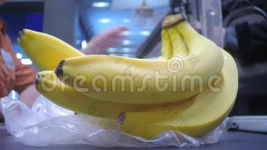香蕉在超市里，<strong>买手</strong>在一堆香蕉的背景下给收银员钱