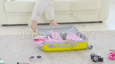 旅游度假理念.. 快乐的年轻女子把五颜六色的夏装装进新的行李箱里