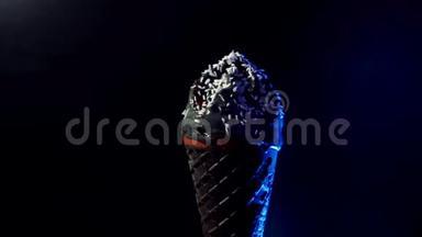 黑色美味的冷冰淇淋在黑色背景下旋转