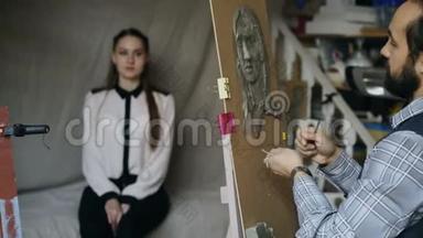 雕塑家在画室中，年轻女子摆着他的姿势，在画布上创作`的面部雕塑