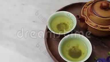 大理石桌上的绿茶和蝴蝶豌豆