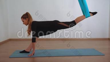 女人坐在空中瑜伽课上做<strong>劈叉</strong>