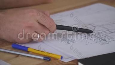 一个男人用戒指`手握住手柄，并展示了图纸的细节