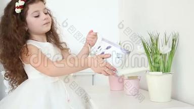 可爱的小女孩在家里用<strong>水缸</strong>跟踪镜头浇花