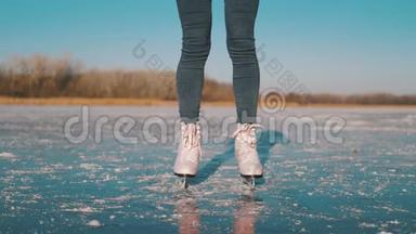在寒冷的冬日，一位年轻女子在结冰的湖面上滑冰。户外冬季<strong>溜冰</strong>场上的<strong>溜冰</strong>者的腿。人
