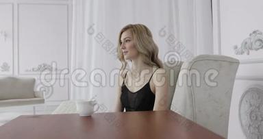 一个穿着黑色内衣的年轻女人正在喝早茶的肖像。