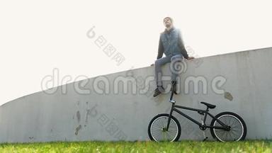 骑自行车坐在草地上的年轻人坐在灯光下