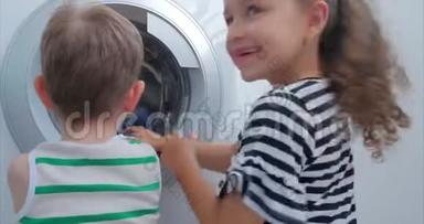 可爱的孩子们在<strong>洗衣机</strong>里看。 气缸旋转机。 概念<strong>洗衣机</strong>，工业