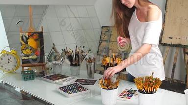 学生画家妇女选择画笔等待绘画课程开始在艺术学校。