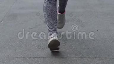 女人的脚慢跑，城市里跑鞋的人跑在公园的混凝土上