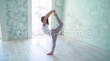 年轻女孩做瑜伽，伸展课，健康的生活方式。 做伸展运动的女孩。 做<strong>劈叉</strong>。
