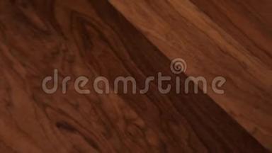 摄像机沿着地板移动，覆盖着一层棕色木制<strong>纹</strong>理的叠层镶木。