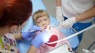生病的孩子在口腔科医生检查时，张开嘴躺在牙椅上，手里拿着工具放在牙科`的<strong>柜子</strong>里