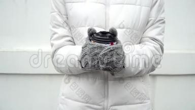 女人用灰色羊毛手套暖手，冬天喝杯咖啡或茶，白色背景带走
