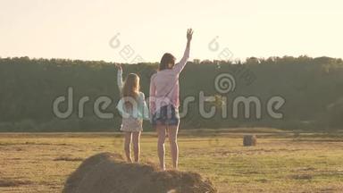 妈妈和女儿在干草堆上玩。 快乐的一家人在<strong>草垛</strong>上玩得开心。 家庭观念。