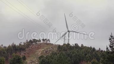 一<strong>台风</strong>力涡轮机在绿色树木之间的山上逆天旋转
