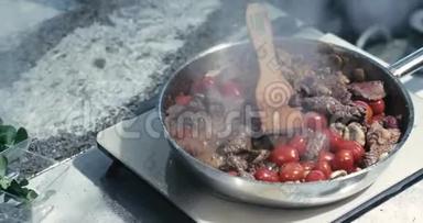 炸锅上的蘑菇和肉，碗里有肉，田里的蘑菇，樱桃番茄，在大理<strong>石桌</strong>上