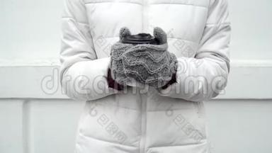 女人用灰色羊毛手套暖手，冬天喝杯咖啡或茶，白色背景带走
