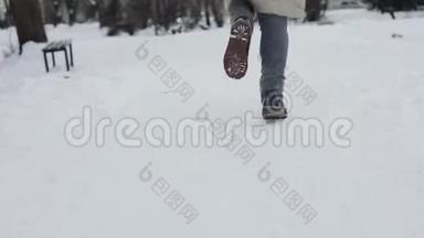 穿着米色羽绒服和时髦靴子的女人在下雪的中央公园里奔跑，下雪了。 慢动作。 后景。