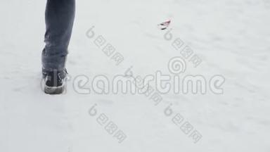 穿着米色<strong>羽绒服</strong>和时髦靴子的女人在下雪的中央公园里奔跑，下雪了。 慢动作。 后景。