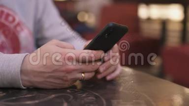一位年轻的商人坐在咖啡馆的桌子旁，用iphone和短信打字——<strong>成功人士</strong>，每天