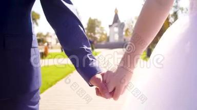 男人和女人<strong>牵着</strong>手在公园里散步。 新婚夫妇<strong>牵着</strong>手在一起