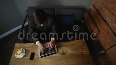 商人在咖啡馆里使用笔记本电脑，手里拿着比特币在木桌上。 上面的风景。 时间间隔