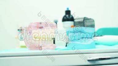在一个牙科医生的柜子里特写粉红色和蓝色的假牙。 假肢器具。