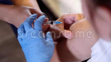 女医生在儿子的帮助下将流感<strong>疫苗</strong>注射到她自己的手中。 女人教儿子<strong>打</strong>针。