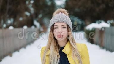 穿着黄色夹克的漂亮女人在雪地<strong>上走来走去</strong>。 下雪了。 户外。 年轻漂亮