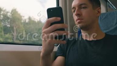 年轻人在火车上使用智能手机，录音和滚动