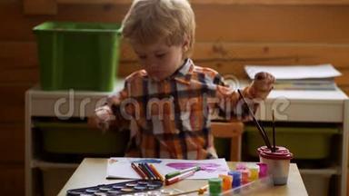 可爱的小男孩在他的相册里画画。 幼儿教育、绘画、天赋、幸福家庭和养育子女的概念