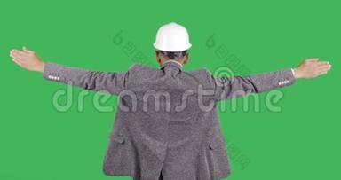 头盔里的建筑工人举起双手，保持平衡。