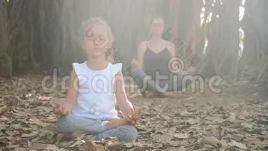 小女孩和小妈妈一起在榕树下冥想