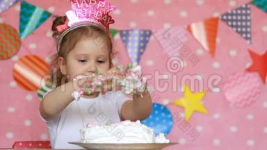 一个小孩的脏手在蛋糕里。 生日派对。 有趣的女孩用甜点舔手指。