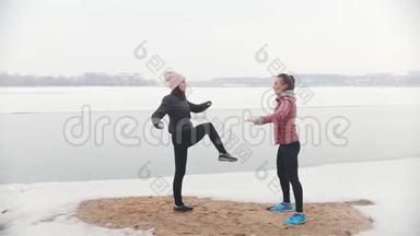 两个苗条的女人站<strong>在</strong>雪地上，为跑步热身